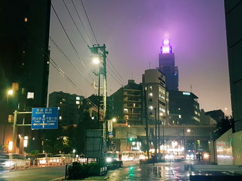 Low angle view of illuminated buildings against sky at night