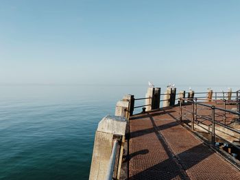 Scenic view of sea against clear sky with classic pier in the foreground