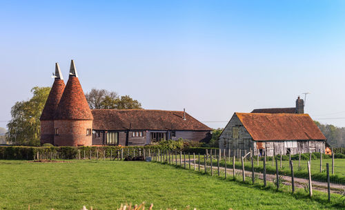 Traditional building on field against clear sky