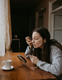 Young woman drinking coffee at home