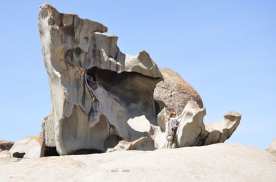 Low angle view of sand against clear blue sky