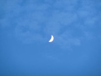 Low angle view of moon against blue sky