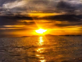 Scenic view of sea against dramatic sky during sunset