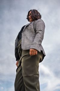 Low angle view of woman standing against sky