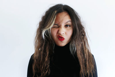 Portrait of beautiful young woman against white background