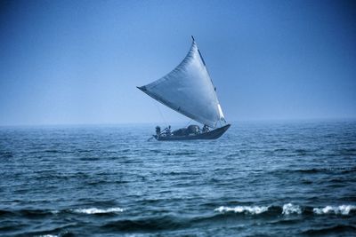 Close-up of sailboat in sea against clear sky