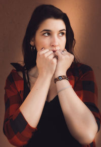 Portrait of young woman against wall