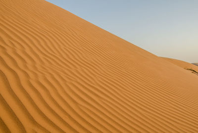 Sand dunes against clear sky