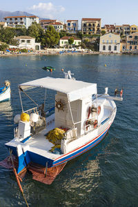 Boats moored in sea against buildings in city