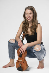 Portrait of young woman standing against white background