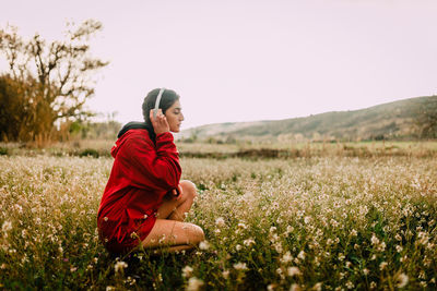 Side view of woman on field against clear sky