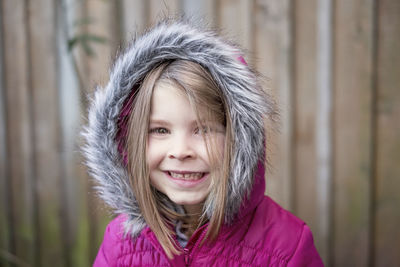 Young girl wearing pink fur hooded jacket