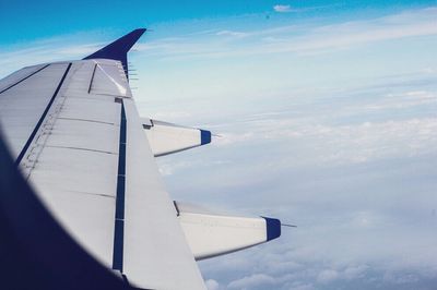 Cropped image of airplane against blue sky