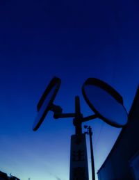 Low angle view of road sign against clear blue sky