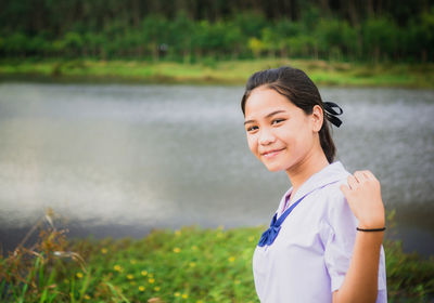 Portrait of girl standing against lake