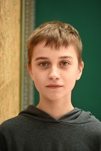 Portrait of young man standing against wall