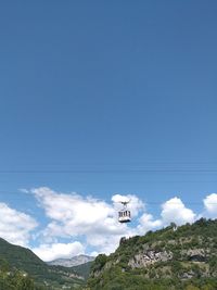 Low angle view of ski lift against blue sky