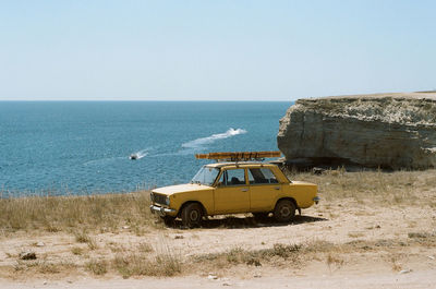 View of car on beach against clear sky