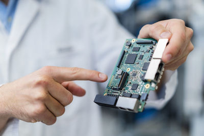 Hand of technician pinting at motherboard