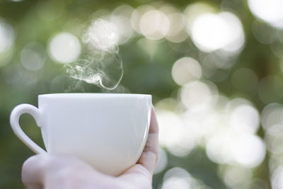 Close-up of hand holding coffee cup