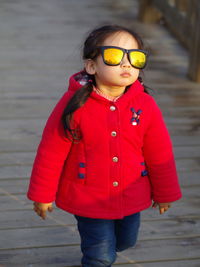 Portrait of young girl wearing sunglasses walking 