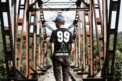 Rear view of person standing against graffiti