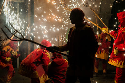 Rear view of people standing at night