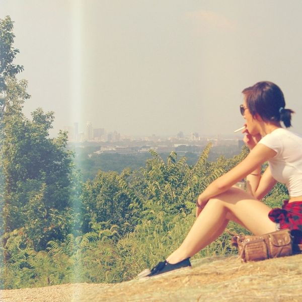 lifestyles, leisure activity, young adult, casual clothing, clear sky, water, sitting, tree, young women, sea, relaxation, person, rear view, nature, full length, sunlight, day