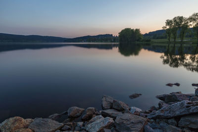 Scenic view of lake against sky at sunset