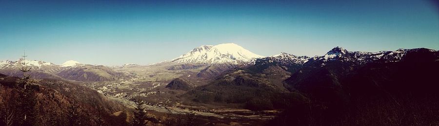 Scenic view of snowcapped mountains against blue sky