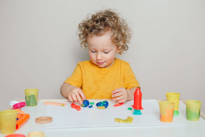 Baby boy playing with sensor kinetic toy playdough. hand brain development. early age  education.