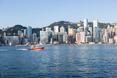 Boats in sea with buildings in background