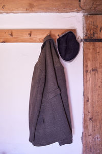 Close-up of clothes drying on wood against wall