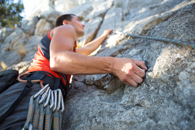 Midsection of man with rope on rock