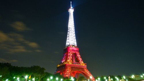 Low angle view of communications tower against sky at night