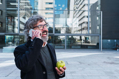 Young man drinking coffee in city
