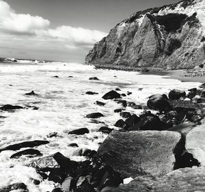 Rocks in sea against sky