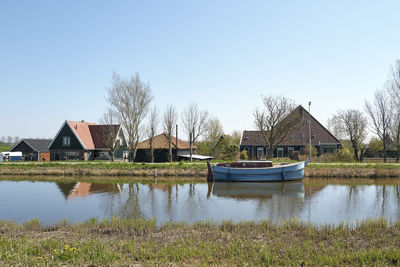 Scenic view of lake and houses against clear sky