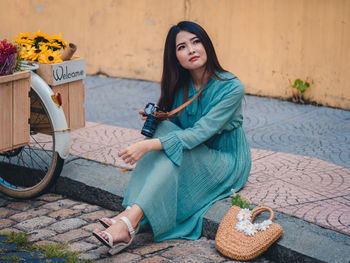 Portrait of young woman sitting outdoors