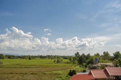 Scenic view of trees and houses against sky