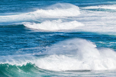 Blue ocean water with white waves in late afternoon