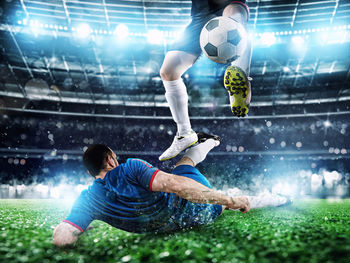 Man playing soccer ball on grass