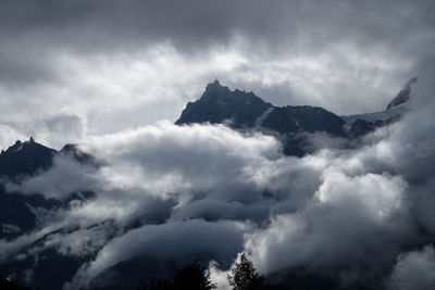 Low angle view of mountains against cloudy sky