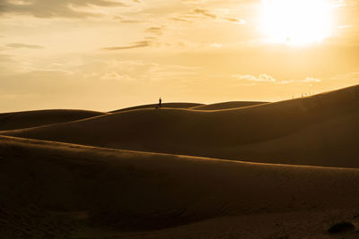 Scenic view of desert against sky during sunset