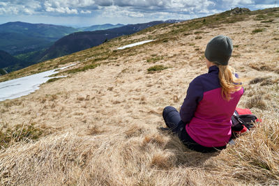 Full length of woman sitting on land