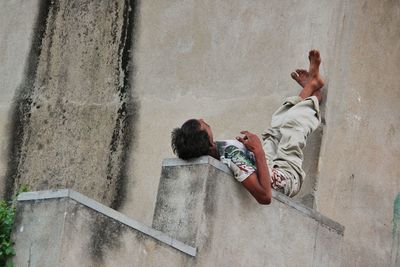 High angle view of friends relaxing on wall