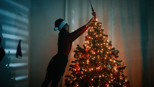 Girl makes christmas tree at home