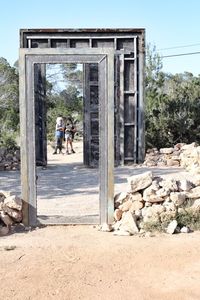 Full length of siblings seen through abandoned door