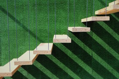 Wooden staircase by green wall