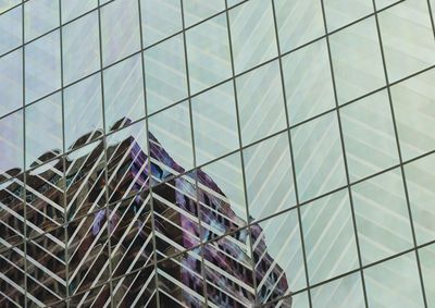 Low angle view of modern glass building against sky